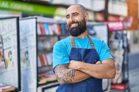 Téléchargez les photos : Young bald man waiter smiling confident standing with arms crossed gesture at coffee shop terrace - en image libre de droit