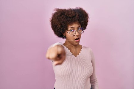 Téléchargez les photos : Jeune femme afro-américaine debout sur fond rose pointant mécontent et frustré à la caméra, en colère et furieux contre vous - en image libre de droit