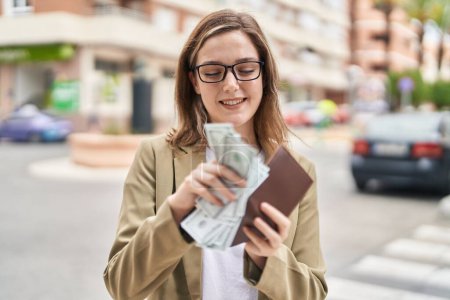 Téléchargez les photos : Young woman business worker counting dollars at street - en image libre de droit