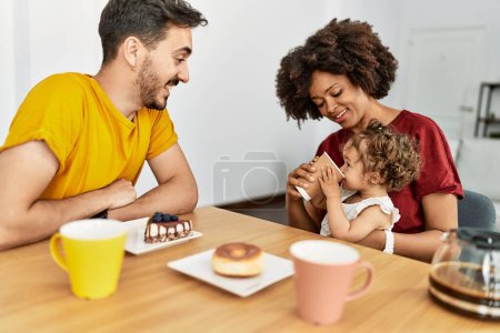 Foto de Couple and daughter having breakfast sitting on table at home - Imagen libre de derechos