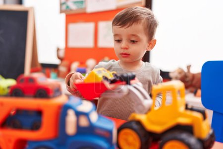 Photo for Adorable hispanic boy playing with truck toy at kindergarten - Royalty Free Image