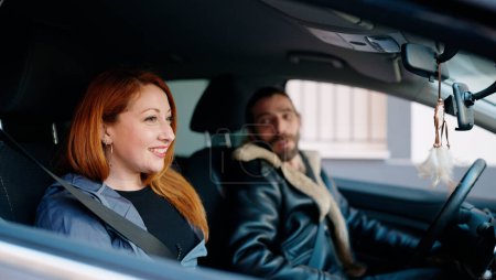 Téléchargez les photos : Homme et femme couple souriant voiture de conduite confiante à la rue - en image libre de droit