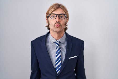 Téléchargez les photos : Homme caucasien avec moustache portant des vêtements de travail en regardant la caméra souffler un baiser sur l'air étant belle et sexy. expression d'amour. - en image libre de droit