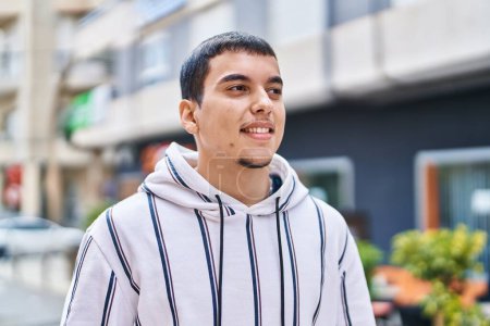 Téléchargez les photos : Jeune homme souriant confiant debout dans la rue - en image libre de droit