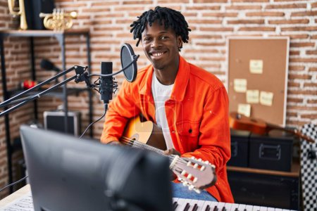 Téléchargez les photos : Homme afro-américain chantant une chanson jouant de la guitare classique au studio de musique - en image libre de droit