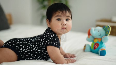 Photo for Adorable hispanic baby lying on bed at bedroom - Royalty Free Image