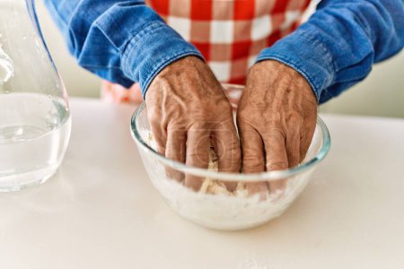 Photo for Senior man cooking dough at kitchen - Royalty Free Image