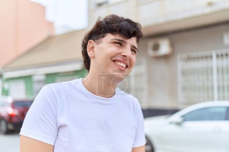 Téléchargez les photos : Homme non binaire souriant confiant regardant du côté de la rue - en image libre de droit