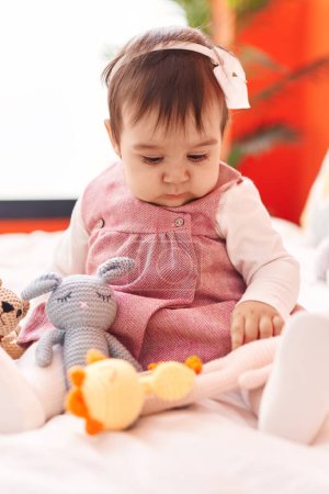 Photo for Adorable hispanic baby playing with toys sitting on bed at bedroom - Royalty Free Image