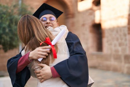 Téléchargez les photos : Man and woman mother and son hugging each other celebrating graduation at university - en image libre de droit