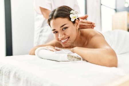 Photo for Young latin woman relaxed having back massage at beauty center - Royalty Free Image