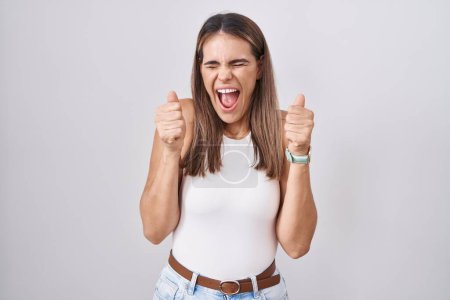 Photo for Hispanic young woman standing over white background excited for success with arms raised and eyes closed celebrating victory smiling. winner concept. - Royalty Free Image