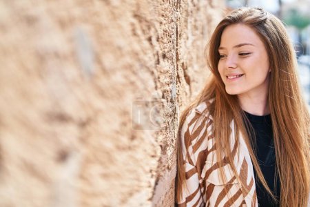 Téléchargez les photos : Jeune femme caucasienne souriant confiant regardant vers le côté à la rue - en image libre de droit