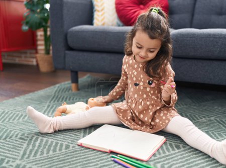 Photo for Adorable hispanic girl reading book sitting on floor at home - Royalty Free Image