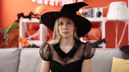 Foto de Young blonde woman wearing witch costume having halloween party at home - Imagen libre de derechos