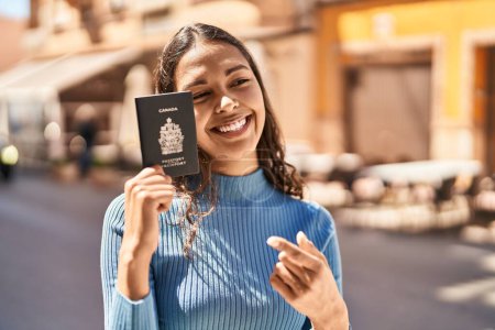 Téléchargez les photos : Jeune femme afro-américaine souriante confiante tenant passeport des États-Unis dans la rue - en image libre de droit