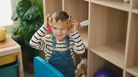 Photo for Adorable caucasian boy smiling confident holding king crown at kindergarten - Royalty Free Image