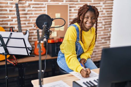 Foto de Mujer afroamericana músico componiendo canción en estudio de música - Imagen libre de derechos