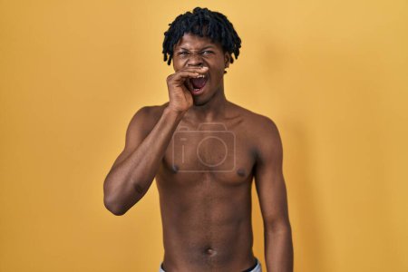 Photo for Young african man with dreadlocks standing shirtless shouting and screaming loud to side with hand on mouth. communication concept. - Royalty Free Image