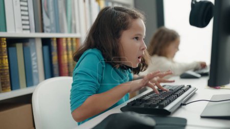 Téléchargez les photos : Deux enfants étudiants utilisant l'ordinateur étudient en classe - en image libre de droit