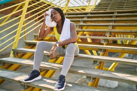 Photo for African american woman sitting on stairs sweating at street - Royalty Free Image
