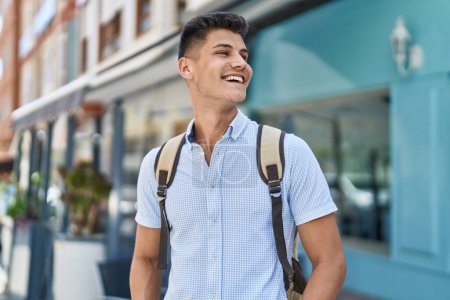 Téléchargez les photos : Young hispanic man student smiling confident standing at street - en image libre de droit