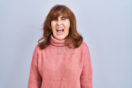Photo for Middle age hispanic woman standing over isolated background angry and mad screaming frustrated and furious, shouting with anger. rage and aggressive concept. - Royalty Free Image