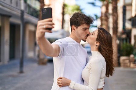 Photo for Mand and woman couple hugging each other make selfie by smartphone at street - Royalty Free Image
