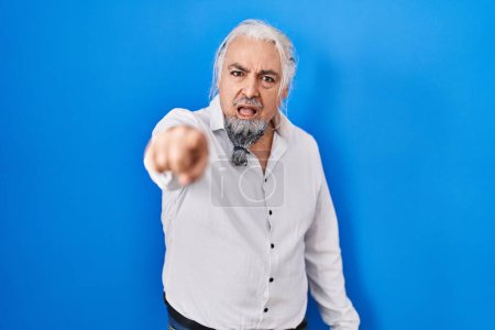 Photo for Middle age man with grey hair standing over blue background pointing displeased and frustrated to the camera, angry and furious with you - Royalty Free Image