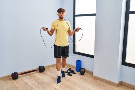 Photo for Arab man with beard training with jump rope relaxed with serious expression on face. simple and natural looking at the camera. - Royalty Free Image