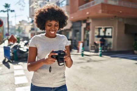 Téléchargez les photos : African american woman smiling confident using professional camera at street - en image libre de droit