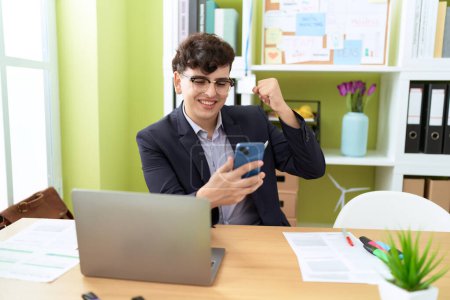 Téléchargez les photos : Non binary man business worker using laptop and smartphone at office - en image libre de droit