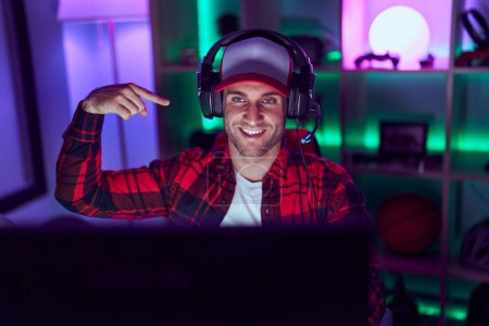 Photo for Young caucasian man playing video games pointing finger to one self smiling happy and proud - Royalty Free Image