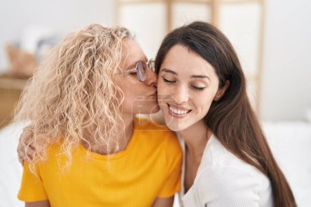 Téléchargez les photos : Deux femmes mère et fille se câlinent et s'embrassent dans la chambre - en image libre de droit