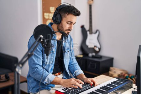 Photo for Young hispanic man composer composing song at music studio - Royalty Free Image