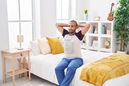 Photo for Young latin man waking up stretching arms at bedroom - Royalty Free Image