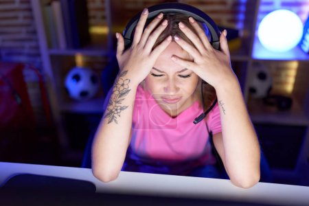 Foto de Joven mujer rubia streamer estresado utilizando la computadora en la sala de juegos - Imagen libre de derechos