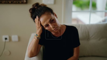 Photo for Middle age hispanic woman suffering for domestic violence with bruise on eyes at home - Royalty Free Image
