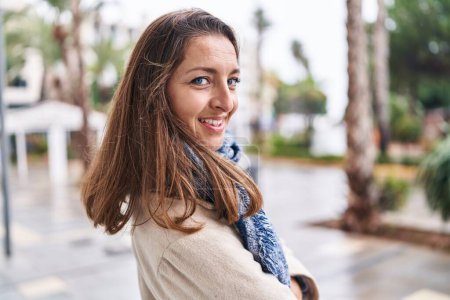 Foto de Mujer joven sonriendo confiada de pie en la calle - Imagen libre de derechos
