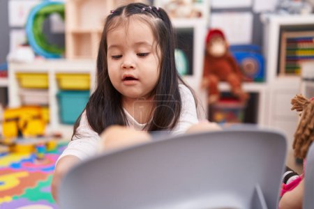 Foto de Adorable niño hispano jugando con juegos de cocina y juguetes en el jardín de infantes - Imagen libre de derechos