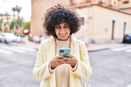 Téléchargez les photos : Young middle east woman excutive smiling confident using smartphone at street - en image libre de droit