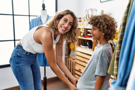 Téléchargez les photos : Mother and son smiling confident choosing clothes at clothing store - en image libre de droit