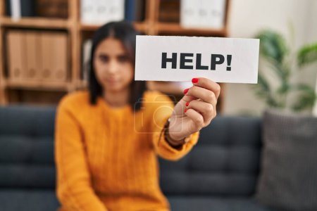 Photo for Young latin woman patient stressed holding help banner at clinic - Royalty Free Image