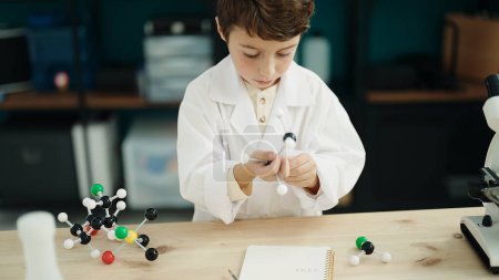 Photo pour Adorable hispanic boy student holding molecules toy at laboratory classroom - image libre de droit