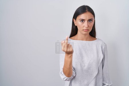 Photo for Young hispanic woman standing over white background showing middle finger, impolite and rude fuck off expression - Royalty Free Image