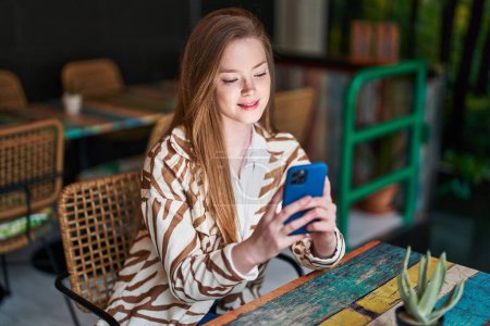Téléchargez les photos : Young caucasian woman using smartphone sitting on table at restaurant - en image libre de droit
