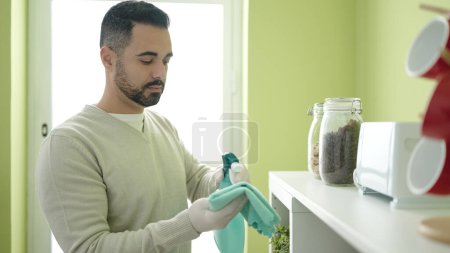 Téléchargez les photos : Jeune homme hispanique nettoyage grille-pain à la maison - en image libre de droit
