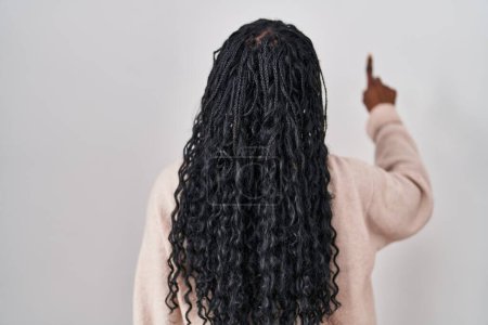 Photo for African woman standing over white background posing backwards pointing ahead with finger hand - Royalty Free Image