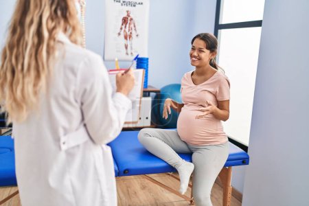 Photo for Young latin woman pregnant patient having physiotherapy session at clinic - Royalty Free Image