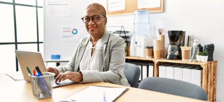 Foto de Trabajadora de negocios afroamericana mayor usando laptop trabajando en oficina - Imagen libre de derechos